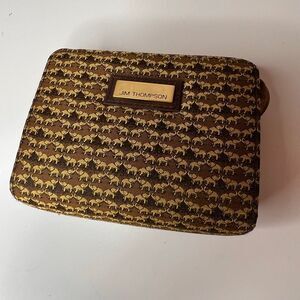 Jim Thompson coin bag featuring a repeating elephant pattern on brown Thai silk